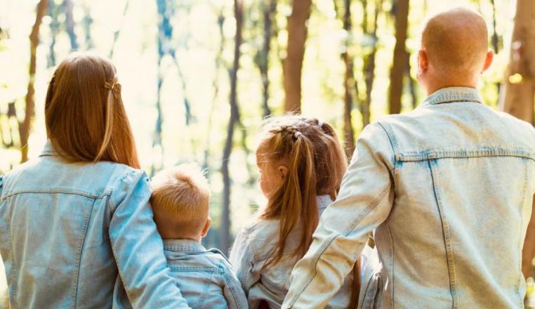 Ein Paar mit zwei Kindern sitzt im Wald.